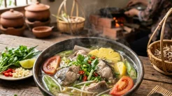 Bát cá tầm nấu canh chua bốc khói nghi ngút với nước dùng trong vắt, cà chua đỏ rực và rau ngổ thơm lừng