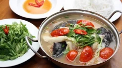 Nồi lẩu cá tầm măng chua sôi sùng sục nghi ngút khói cùng sụn cá giòn sần sật và các loại rau nhúng tươi ngon